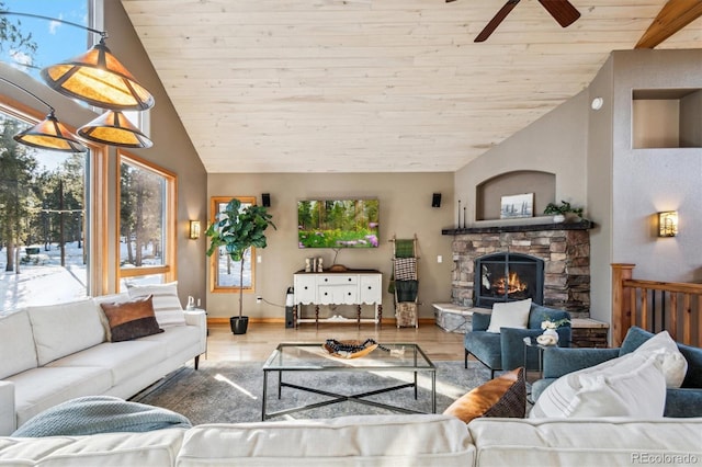 living room featuring ceiling fan, light hardwood / wood-style floors, a stone fireplace, vaulted ceiling, and wooden ceiling