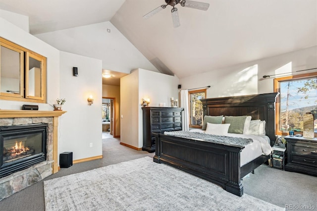 carpeted bedroom featuring ceiling fan, lofted ceiling, and a stone fireplace