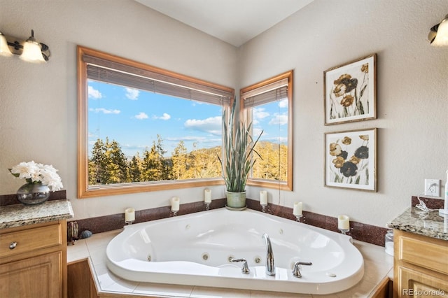 bathroom featuring tiled tub and vanity