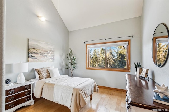 bedroom featuring lofted ceiling and light hardwood / wood-style floors