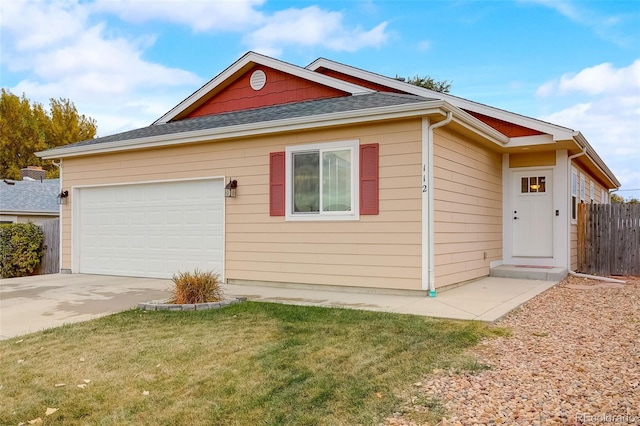 single story home featuring an attached garage, a front lawn, fence, roof with shingles, and driveway