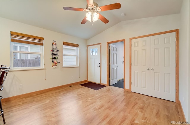 foyer featuring baseboards, lofted ceiling, a ceiling fan, and light wood finished floors