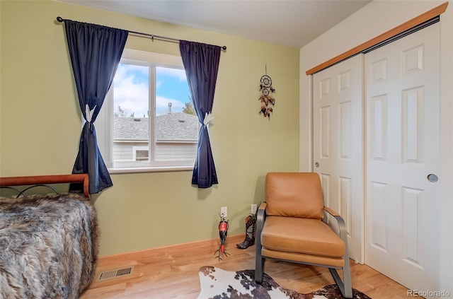 bedroom with visible vents, baseboards, light wood-style floors, and a closet