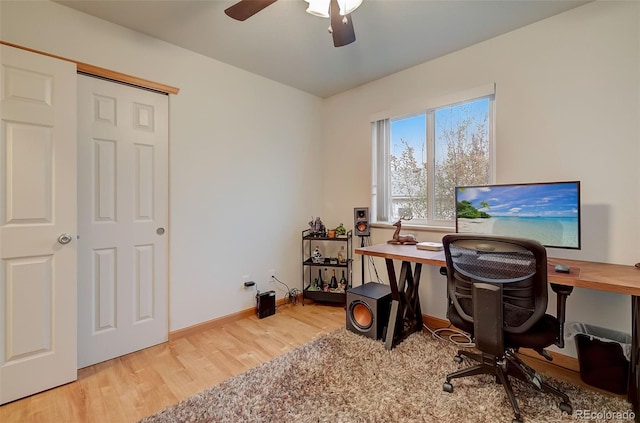 home office with light wood-style floors, baseboards, and ceiling fan