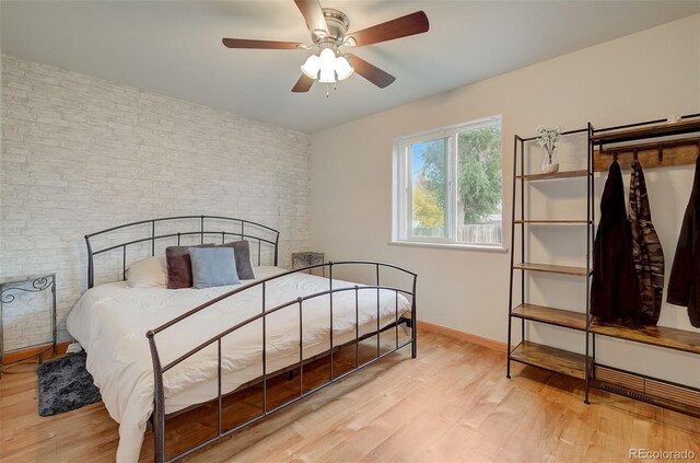 bedroom featuring a ceiling fan, wood finished floors, and baseboards