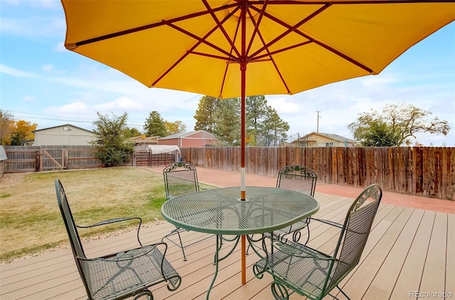 deck with a yard, outdoor dining area, and a fenced backyard