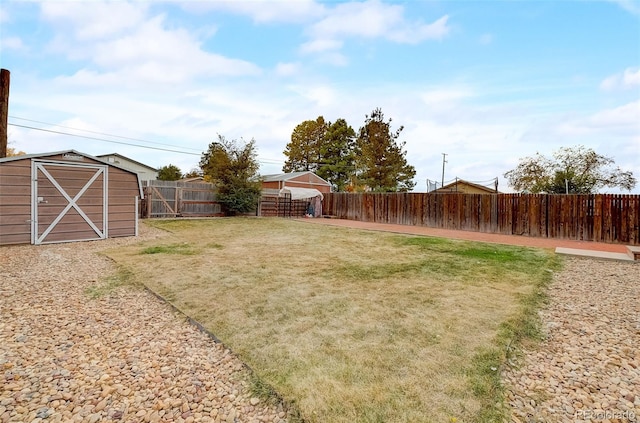 view of yard with an outbuilding, a storage unit, and a fenced backyard