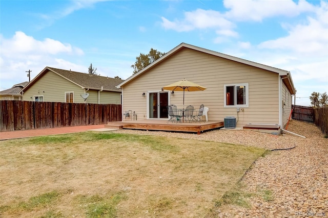 back of property featuring a deck, central AC unit, a fenced backyard, and a lawn