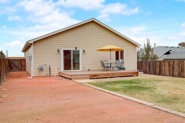 back of house with a yard, a deck, a patio, and a fenced backyard