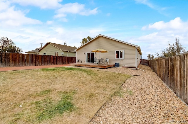 back of property featuring a yard, a fenced backyard, central AC, and a wooden deck