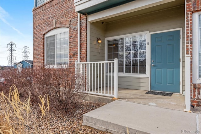 doorway to property featuring brick siding