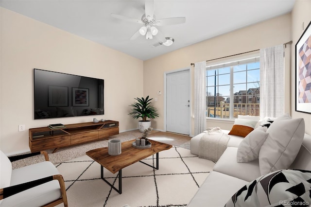 living area with ceiling fan and visible vents