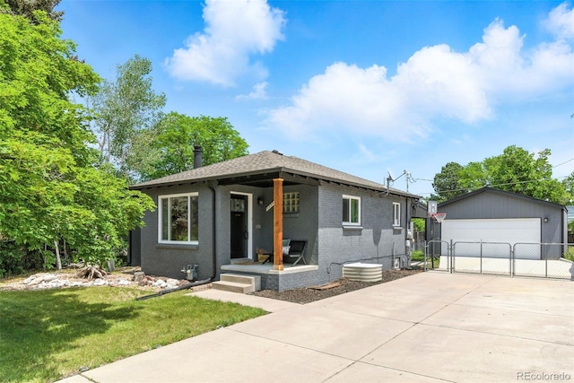 2050 S Wolff St, Denver, CO 80219 - view of front facade with brick siding, a gate, a detached garage, an outdoor structure, and roof with shingles