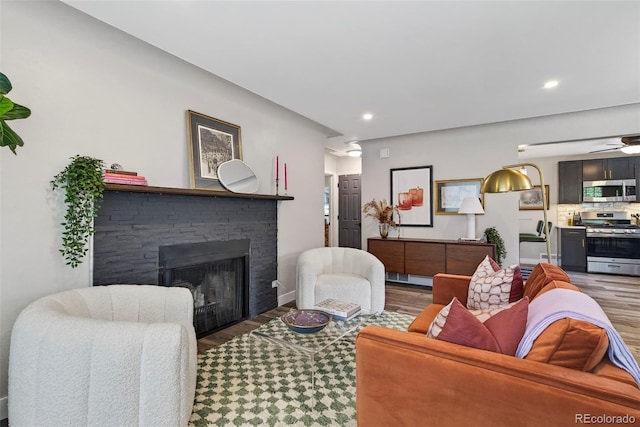 2050 S Wolff St, Denver, CO 80219 - living area with wood finished floors, a stone fireplace, a ceiling fan, and recessed lighting
