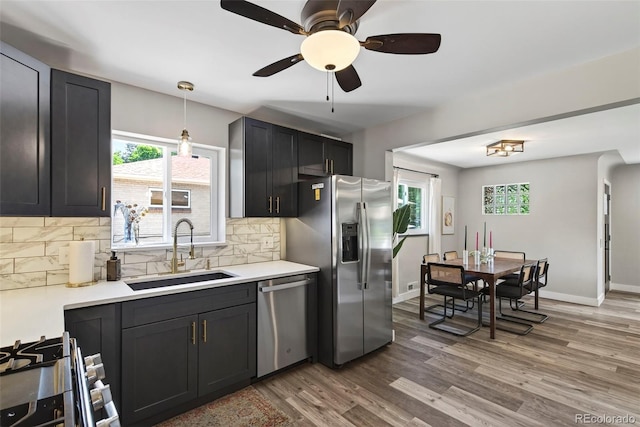 2050 S Wolff St, Denver, CO 80219 - kitchen featuring appliances with stainless steel finishes, wood finished floors, a ceiling fan, and healthy amount of natural light