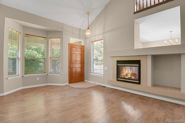 9874 Grove St Unit B, Westminster, CO 80031 - foyer entrance with wood finished floors, a chandelier, a tiled fireplace, and high vaulted ceiling