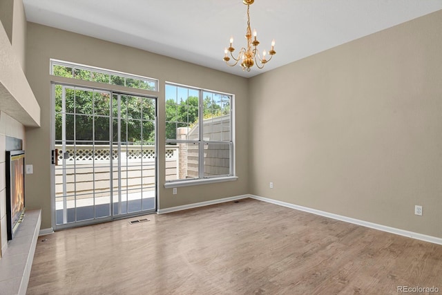 9874 Grove St Unit B, Westminster, CO 80031 - spare room with a chandelier, healthy amount of natural light, wood finished floors, and a tiled fireplace