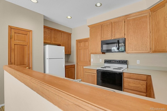 9874 Grove St Unit B, Westminster, CO 80031 - kitchen featuring black microwave, range with electric stovetop, freestanding refrigerator, recessed lighting, and light countertops