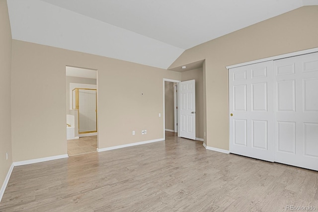 9874 Grove St Unit B, Westminster, CO 80031 - unfurnished bedroom with lofted ceiling, light wood-type flooring, a closet, and ensuite bath