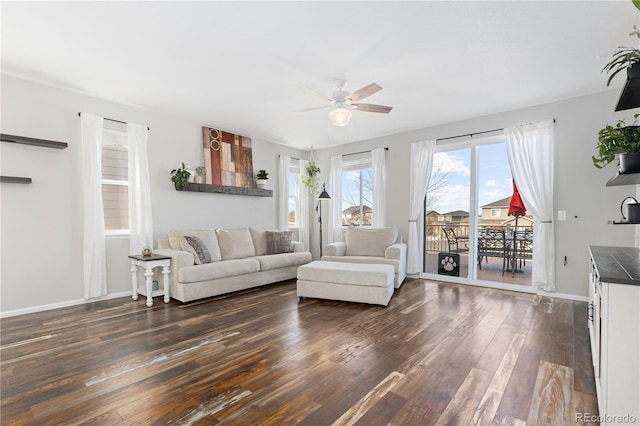 living room featuring ceiling fan and dark hardwood / wood-style flooring