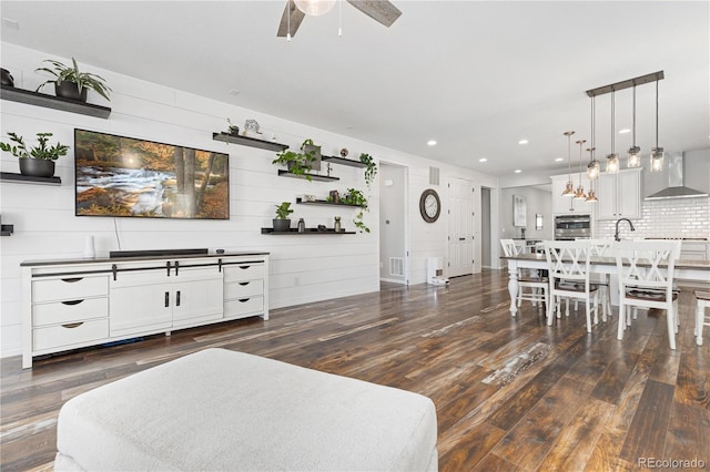 living room featuring dark hardwood / wood-style floors, sink, and ceiling fan