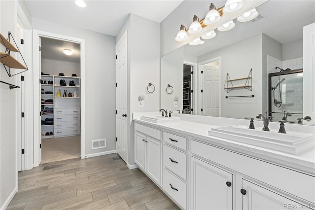 bathroom with vanity, hardwood / wood-style floors, and a shower with shower door