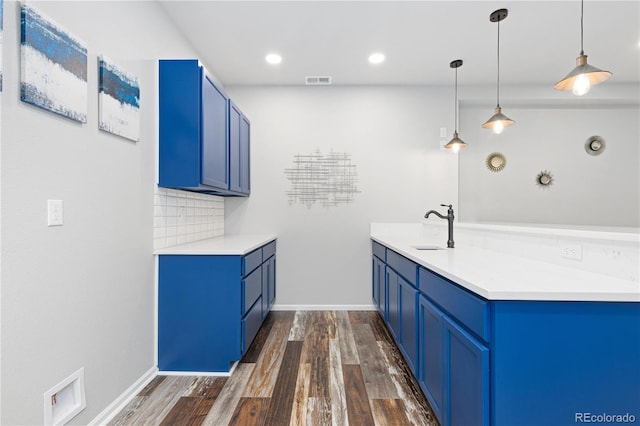 kitchen featuring blue cabinetry, decorative light fixtures, dark wood-type flooring, and decorative backsplash