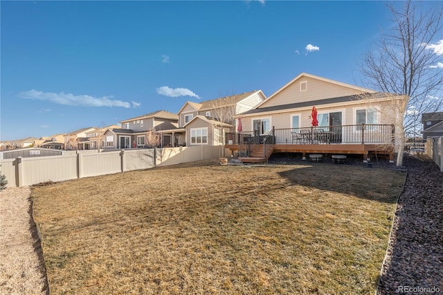 rear view of house with a lawn and a deck