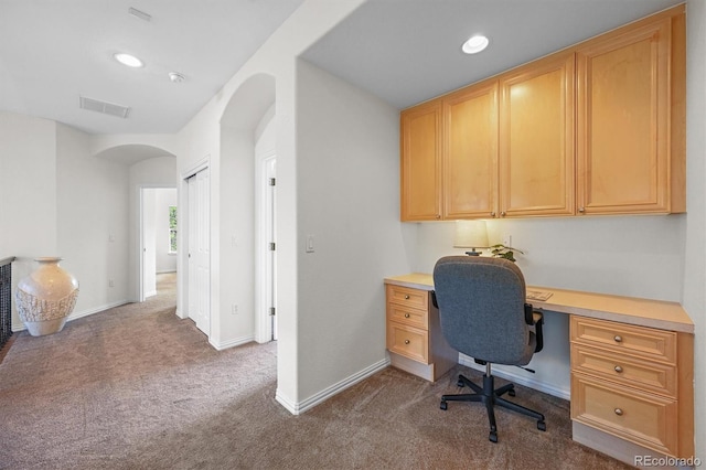 office space featuring dark colored carpet, arched walkways, built in study area, recessed lighting, and baseboards