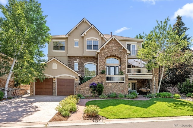 view of front of house with stucco siding, stone siding, driveway, a front yard, and an attached garage