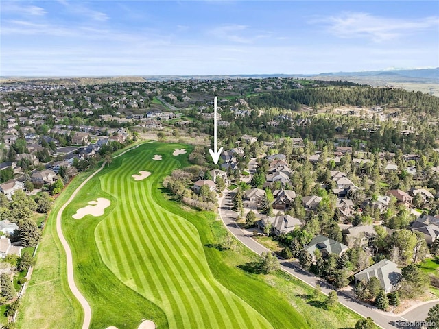 aerial view of property's location with nearby suburban area, a golf course, and a mountainous background