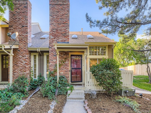 1990 S Helena St Unit H, Aurora, CO 80013 - entrance to property featuring a chimney, roof with shingles, and brick siding