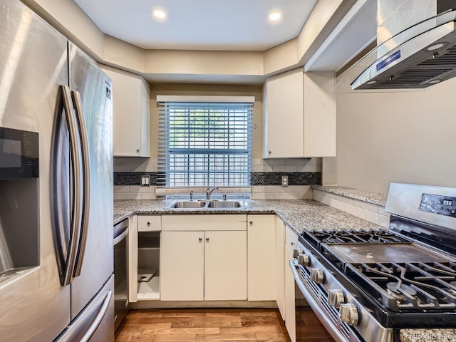 1990 S Helena St Unit H, Aurora, CO 80013 - kitchen with stainless steel appliances, ventilation hood, decorative backsplash, light wood-style flooring, and white cabinets
