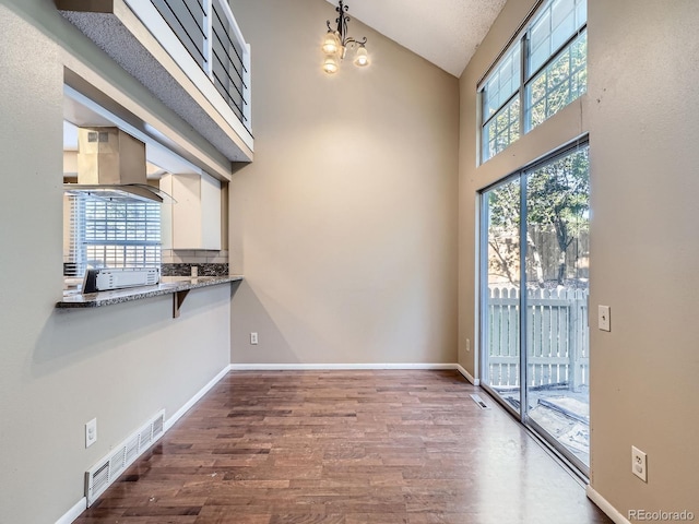 1990 S Helena St Unit H, Aurora, CO 80013 - unfurnished dining area featuring dark wood finished floors, high vaulted ceiling, and a chandelier