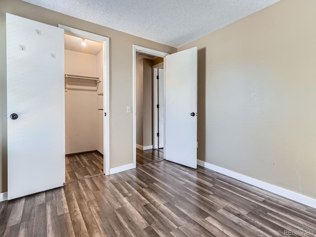 1990 S Helena St Unit H, Aurora, CO 80013 - unfurnished bedroom with wood finished floors, a textured ceiling, and a spacious closet