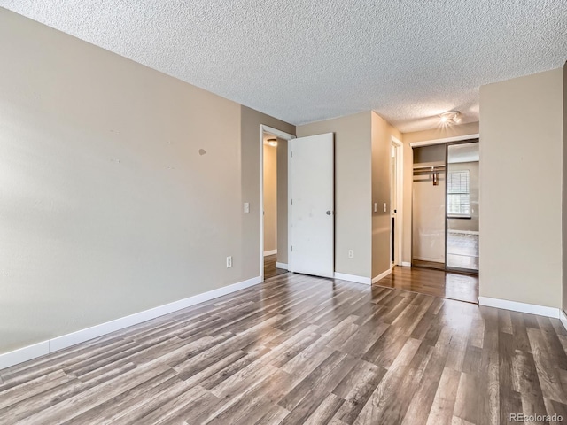 1990 S Helena St Unit H, Aurora, CO 80013 - unfurnished bedroom with wood finished floors and a textured ceiling