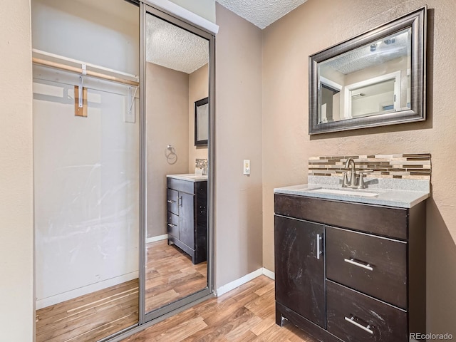 1990 S Helena St Unit H, Aurora, CO 80013 - bathroom featuring wood finished floors, a textured ceiling, and vanity