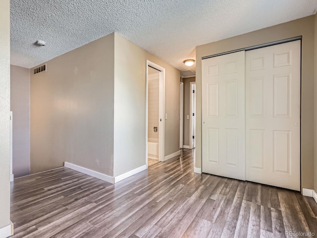 1990 S Helena St Unit H, Aurora, CO 80013 - unfurnished bedroom featuring wood finished floors, a closet, and a textured ceiling