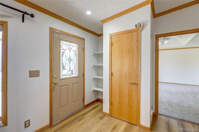 200 E 6th St, Flagler, CO 80815 - entrance foyer with crown molding, light wood finished floors, and a textured ceiling