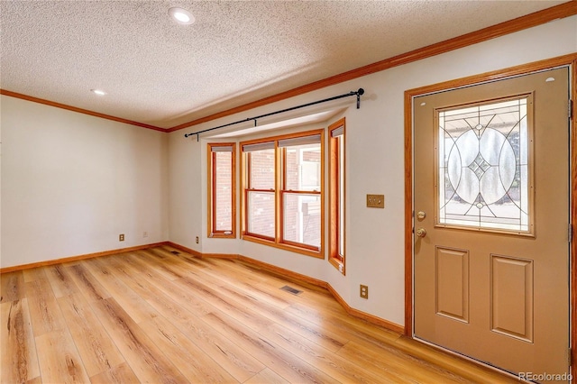 200 E 6th St, Flagler, CO 80815 - entryway with a textured ceiling, crown molding, light wood-style floors, and recessed lighting