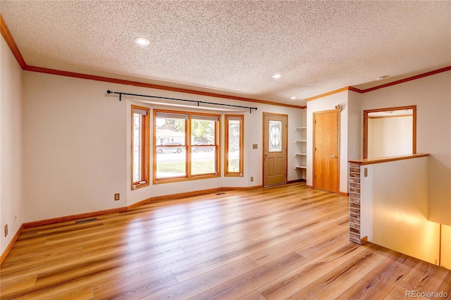 200 E 6th St, Flagler, CO 80815 - spare room with a textured ceiling, light wood-style flooring, ornamental molding, and recessed lighting
