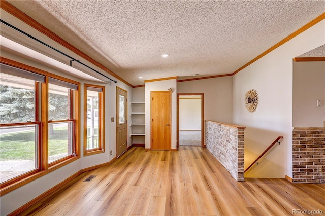 200 E 6th St, Flagler, CO 80815 - empty room with ornamental molding, a textured ceiling, light wood-type flooring, healthy amount of natural light, and recessed lighting