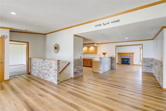 200 E 6th St, Flagler, CO 80815 - living area featuring a textured ceiling, crown molding, light wood-style flooring, recessed lighting, and a fireplace