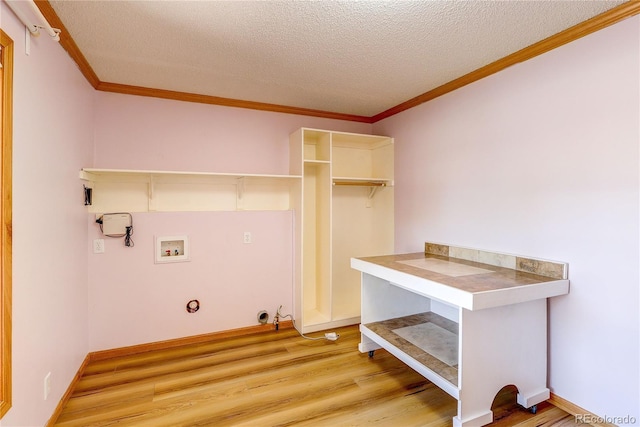 200 E 6th St, Flagler, CO 80815 - washroom featuring hookup for a gas dryer, a textured ceiling, light wood-style flooring, crown molding, and hookup for a washing machine