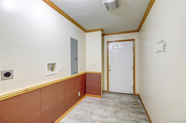 200 E 6th St, Flagler, CO 80815 - doorway featuring electric panel, a textured ceiling, ornamental molding, and wainscoting