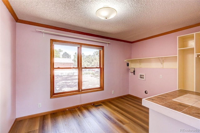 200 E 6th St, Flagler, CO 80815 - washroom with wood finished floors, hookup for an electric dryer, hookup for a washing machine, ornamental molding, and a textured ceiling