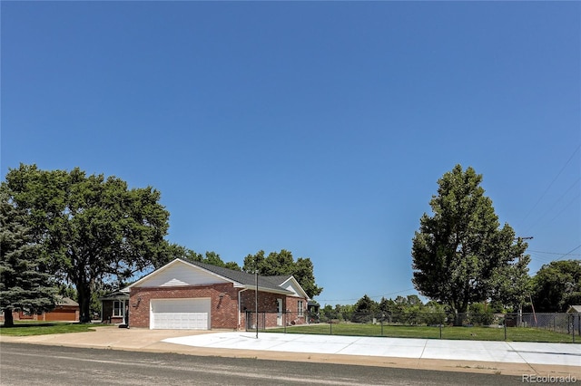 200 E 6th St, Flagler, CO 80815 - view of front of house featuring an attached garage, brick siding, and concrete driveway