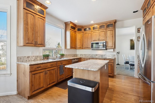 kitchen with a wealth of natural light, a center island, sink, and appliances with stainless steel finishes