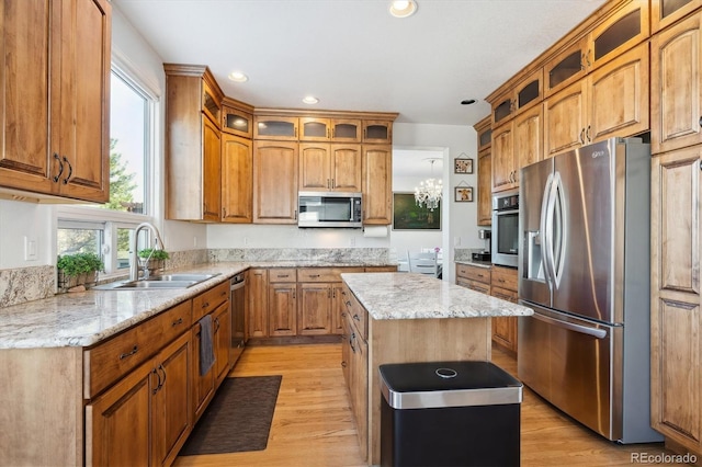 kitchen with a kitchen island, light hardwood / wood-style floors, sink, and appliances with stainless steel finishes