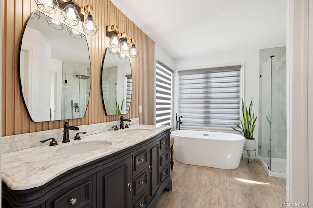 bathroom featuring hardwood / wood-style flooring, vanity, shower with separate bathtub, and wooden walls